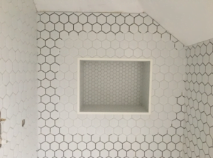 Hexagonal tiles being installed into the loft bathroom