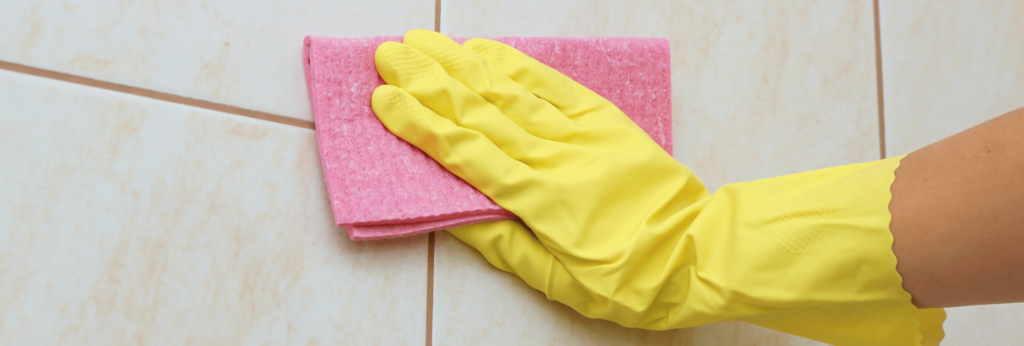 Hand cleaning tiles to remove mould and dirt